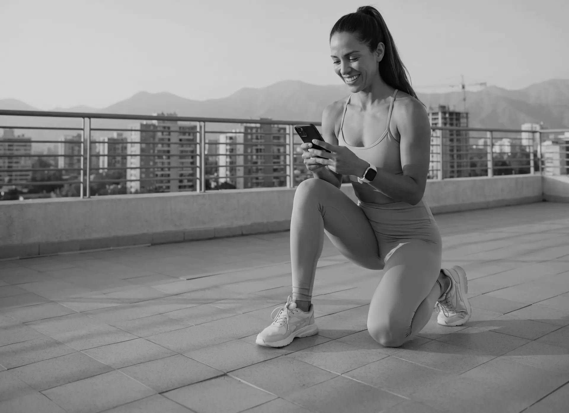 Una alumna sonríe mientras revisa su plan en el celular, en un descanso de su entrenamiento